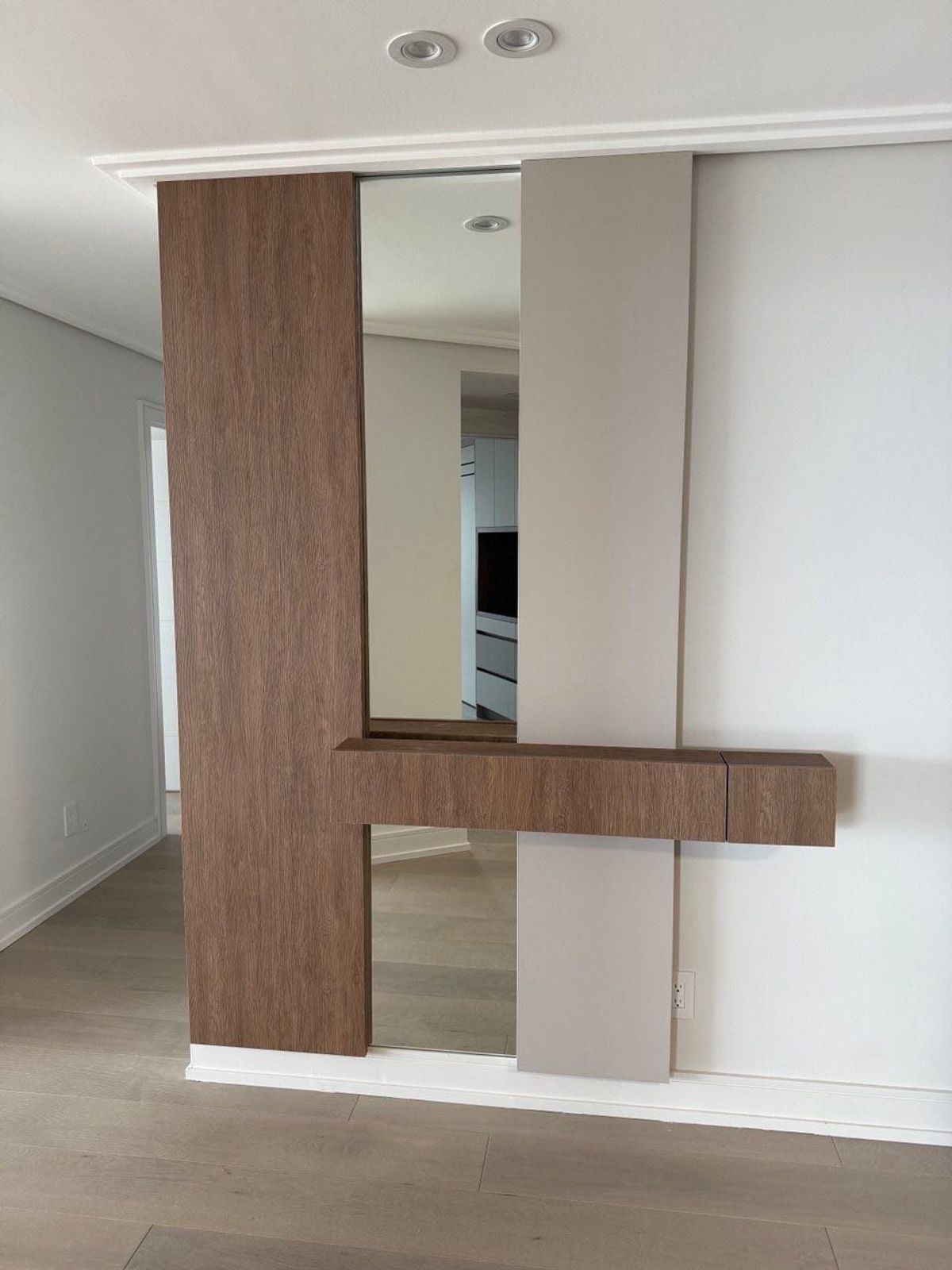 Custom wood wall unit with mirror panel and built-in shelf in a Vaughan home