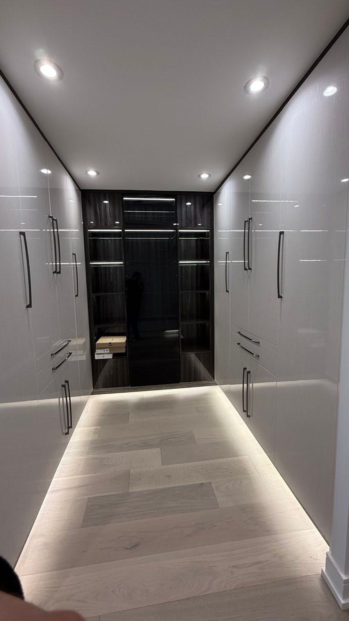 Custom built-in wardrobe with mirrored doors and lit base in a Vaughan home