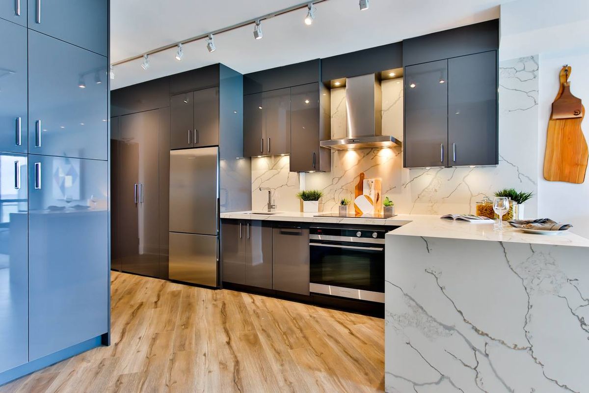 Blue-grey kitchen cabinets with light hardwood flooring in a Vaughan home