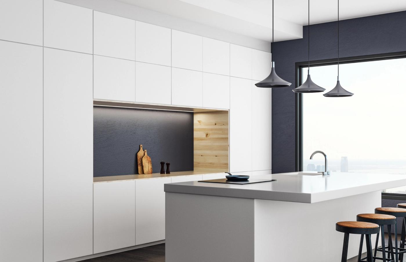 White custom kitchen with a dark accent wall and pendant lights, designed by KABCO
