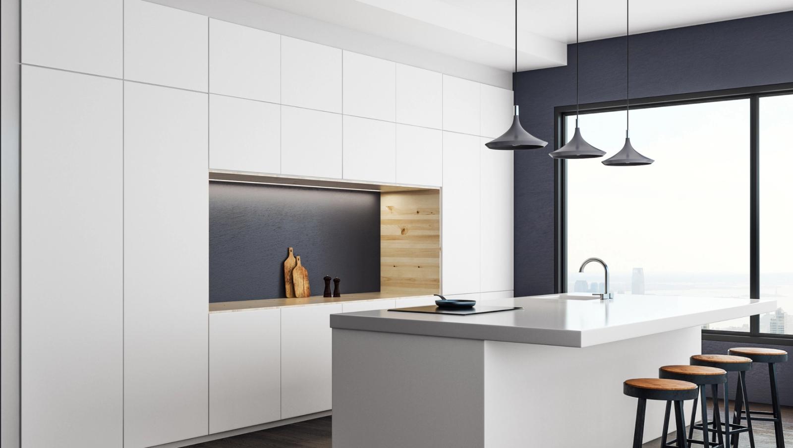 White custom kitchen with a dark accent wall and pendant lights, designed by KABCO