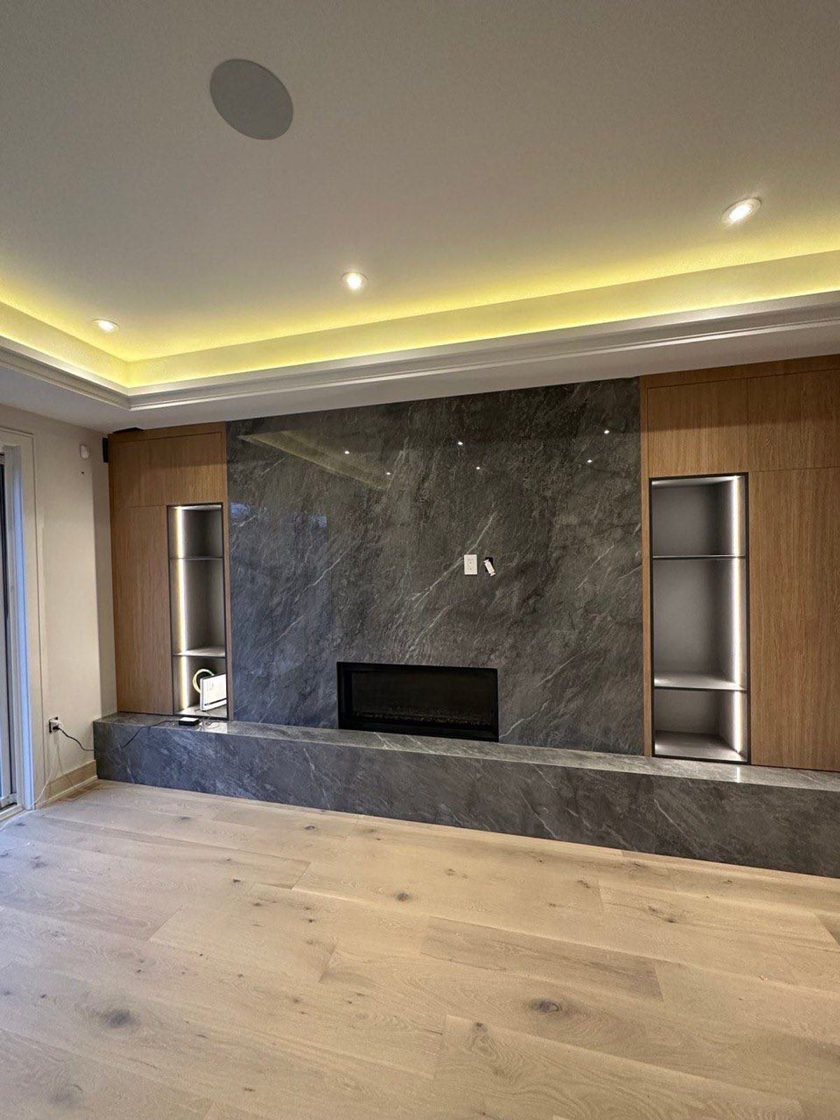 Modern media wall unit with fireplace, wood panels and built-in shelving