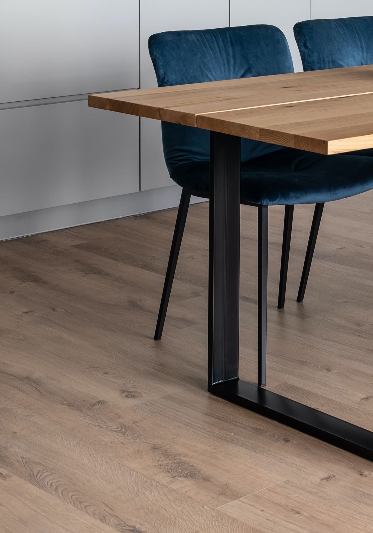 Solid hardwood flooring under a dining table with blue chairs